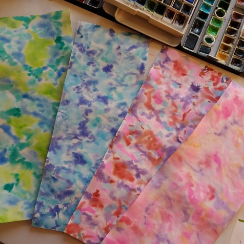 Feuilles peintes avec des taches d'aquarelle de couleurs différentes pour faire des perles de papier roulé
