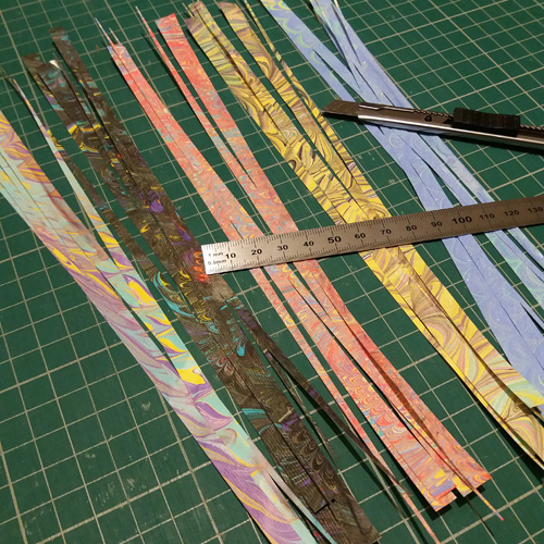 Bandes de papier marbré de couleurs différentes pour faire des minis perles roulées de moins d'un centimètre